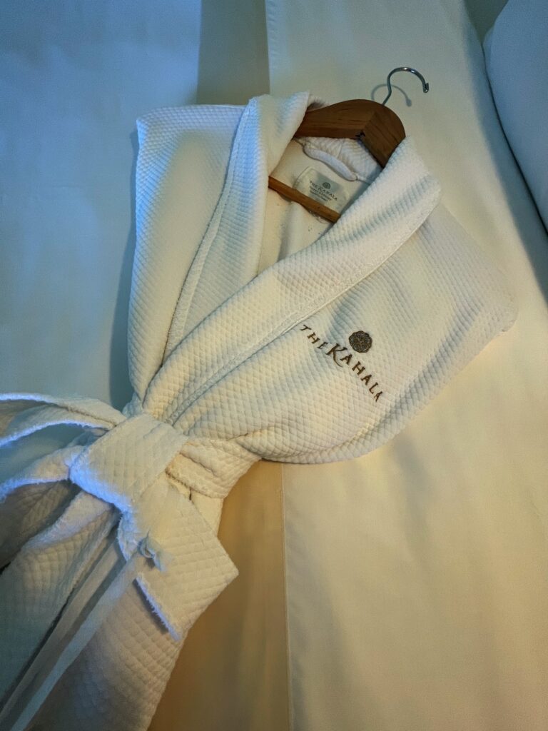 One of the Kahala Hotel and Resort hotel robes laying on a bed