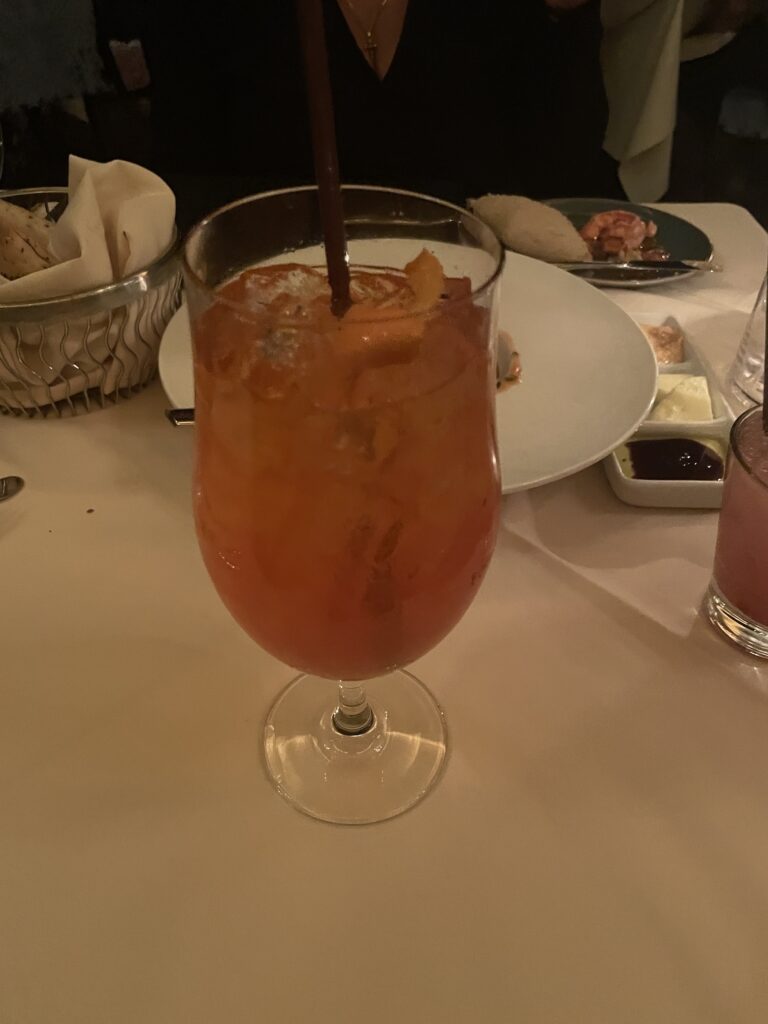 a glass of orange liquid with a straw