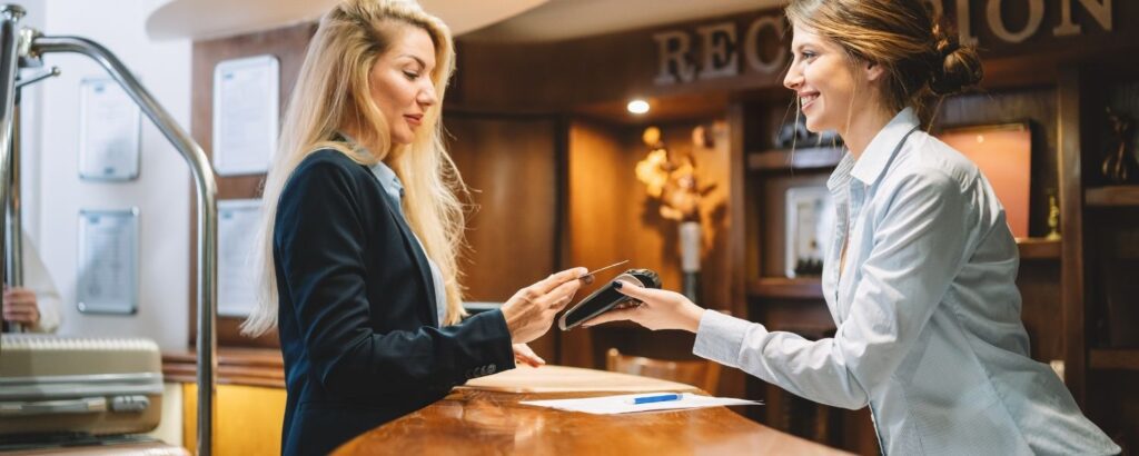 Female using credit card at hotel reception