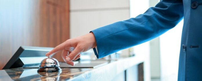 Person ringing bell at hotel desk