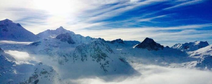 a mountain range with clouds and sun