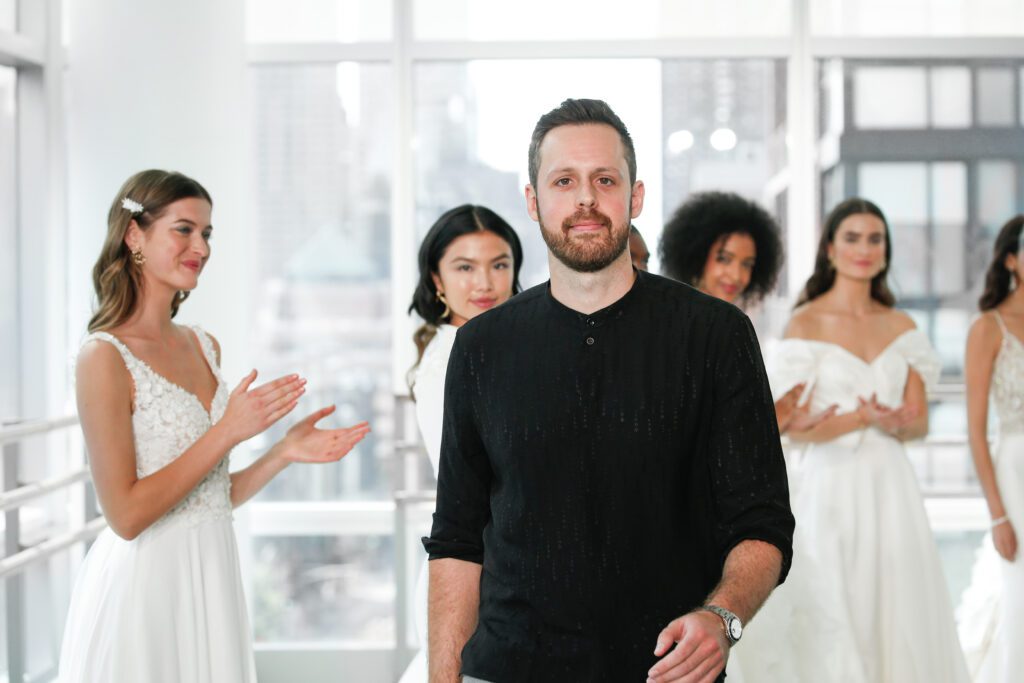 Justin Warshaw of Justin Alexander Design walking among brides in dresses for one of the Marriott Bonvoy Moments