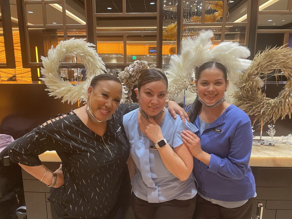 three ladies are posing for photo session while smiling