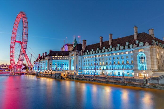 a building with lights on the side of the water