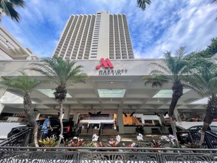 a building with palm trees and a sign