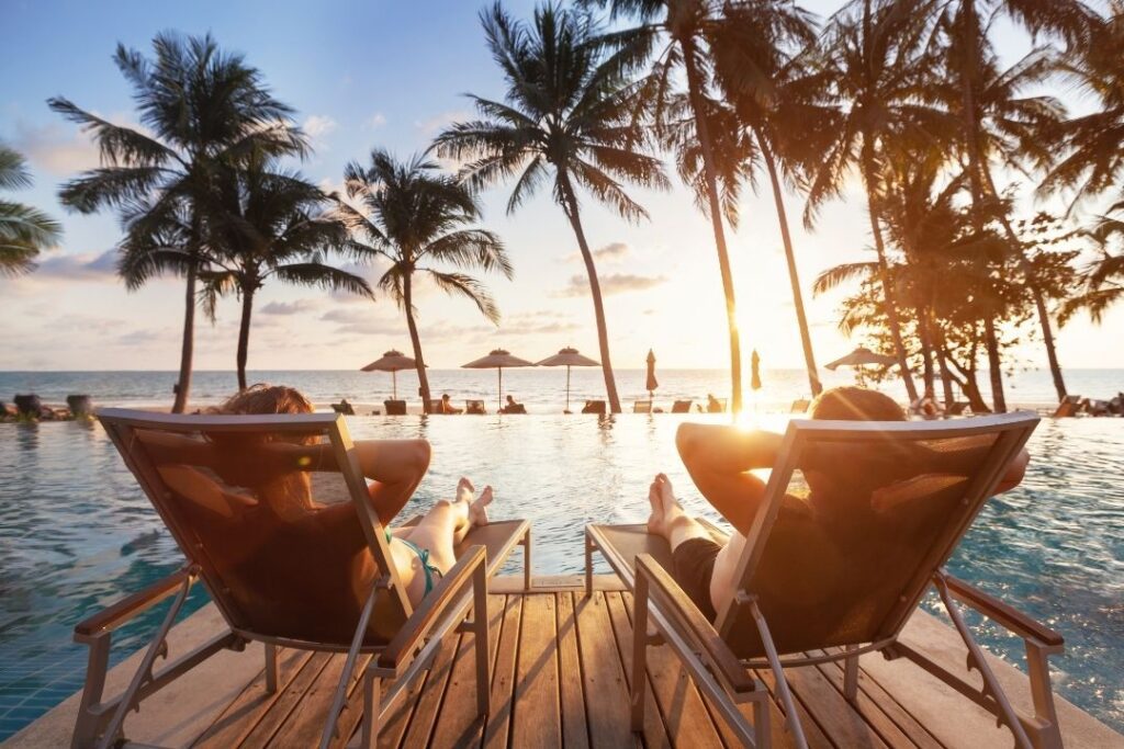 Couple lounging by pool enjoying Virtuoso VIP Perks and amenities.