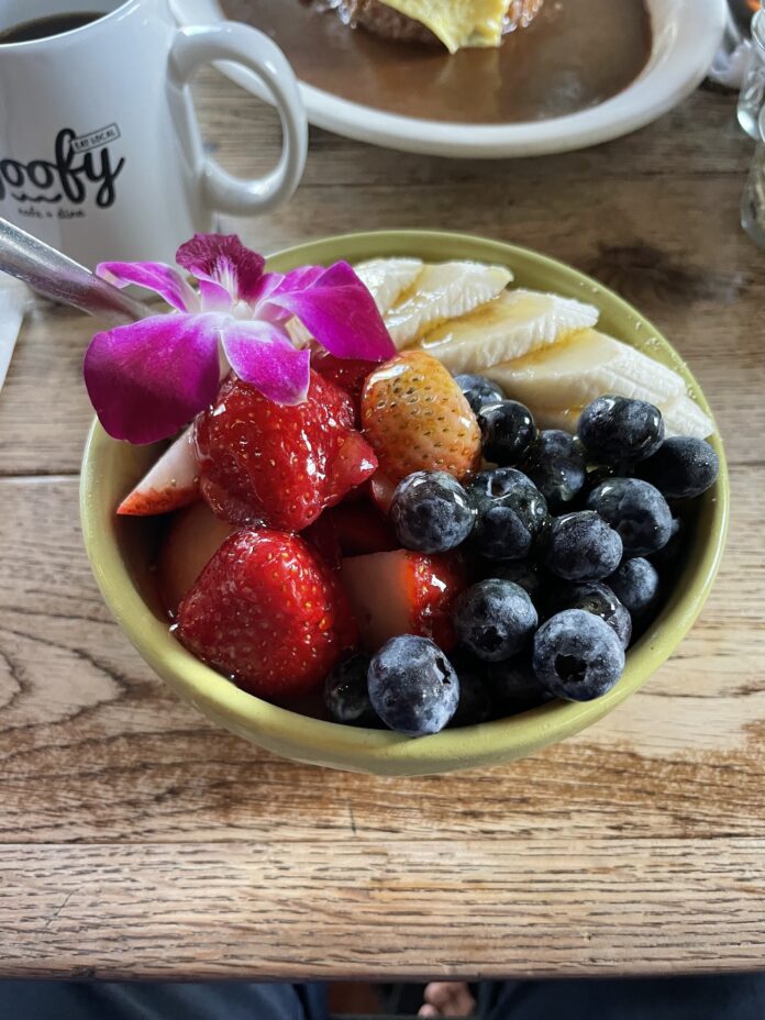 a bowl of fruit with a flower on top