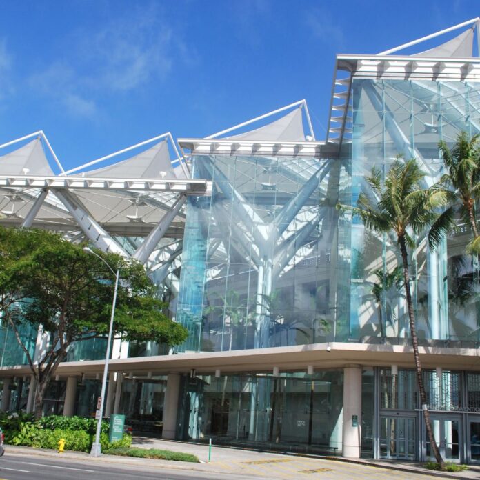 a building with glass walls and trees
