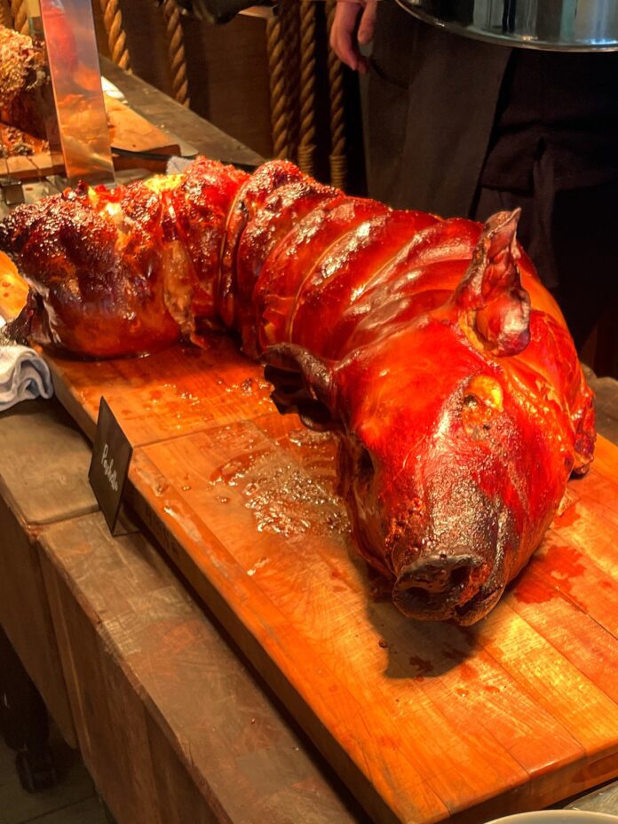 a large cooked pig on a wooden surface