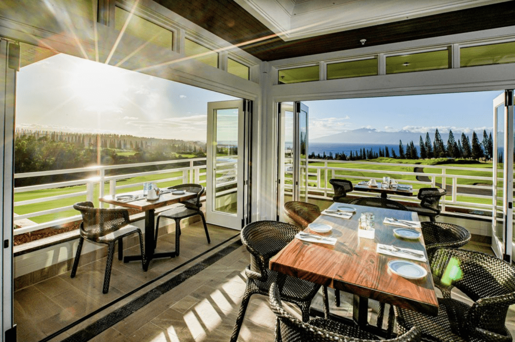 a table and chairs in a room with a view of the golf course