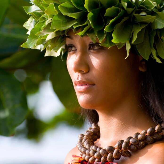 a woman wearing a necklace and a green wreath