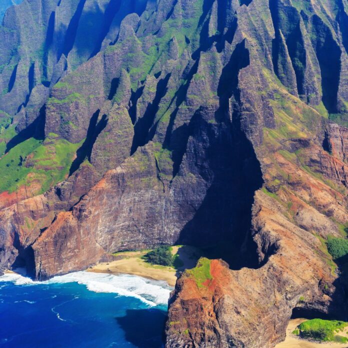 a large rocky mountain with a beach and a body of water