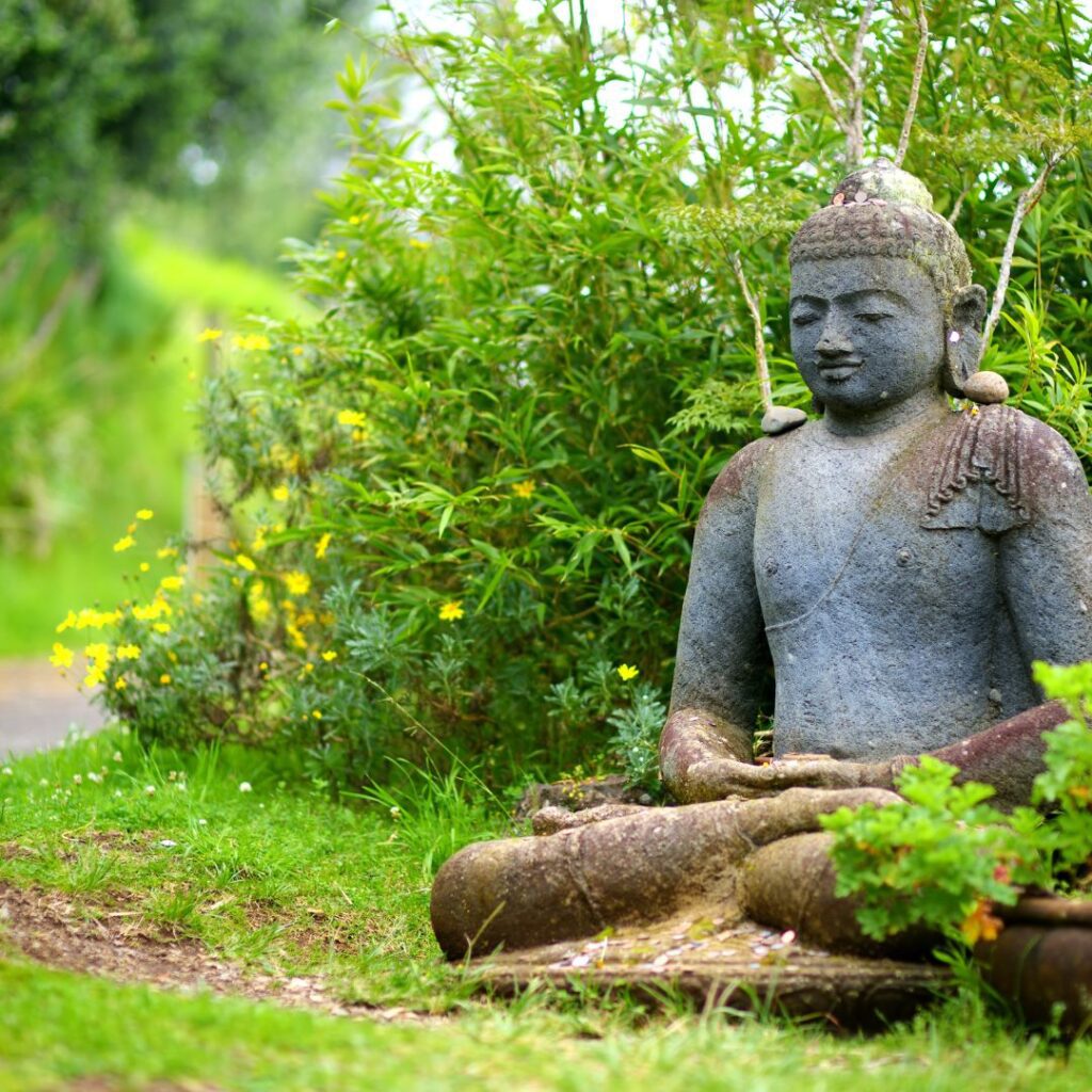a stone statue of a man sitting in a lotus position