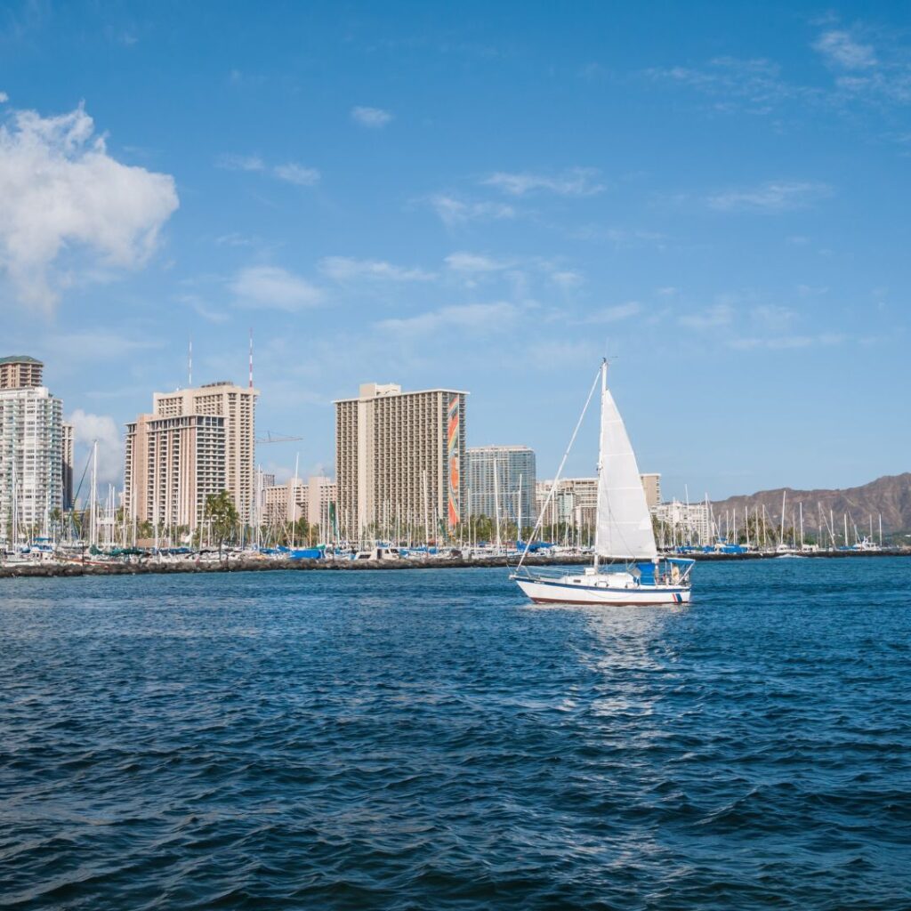 a sailboat in the water with buildings in the background