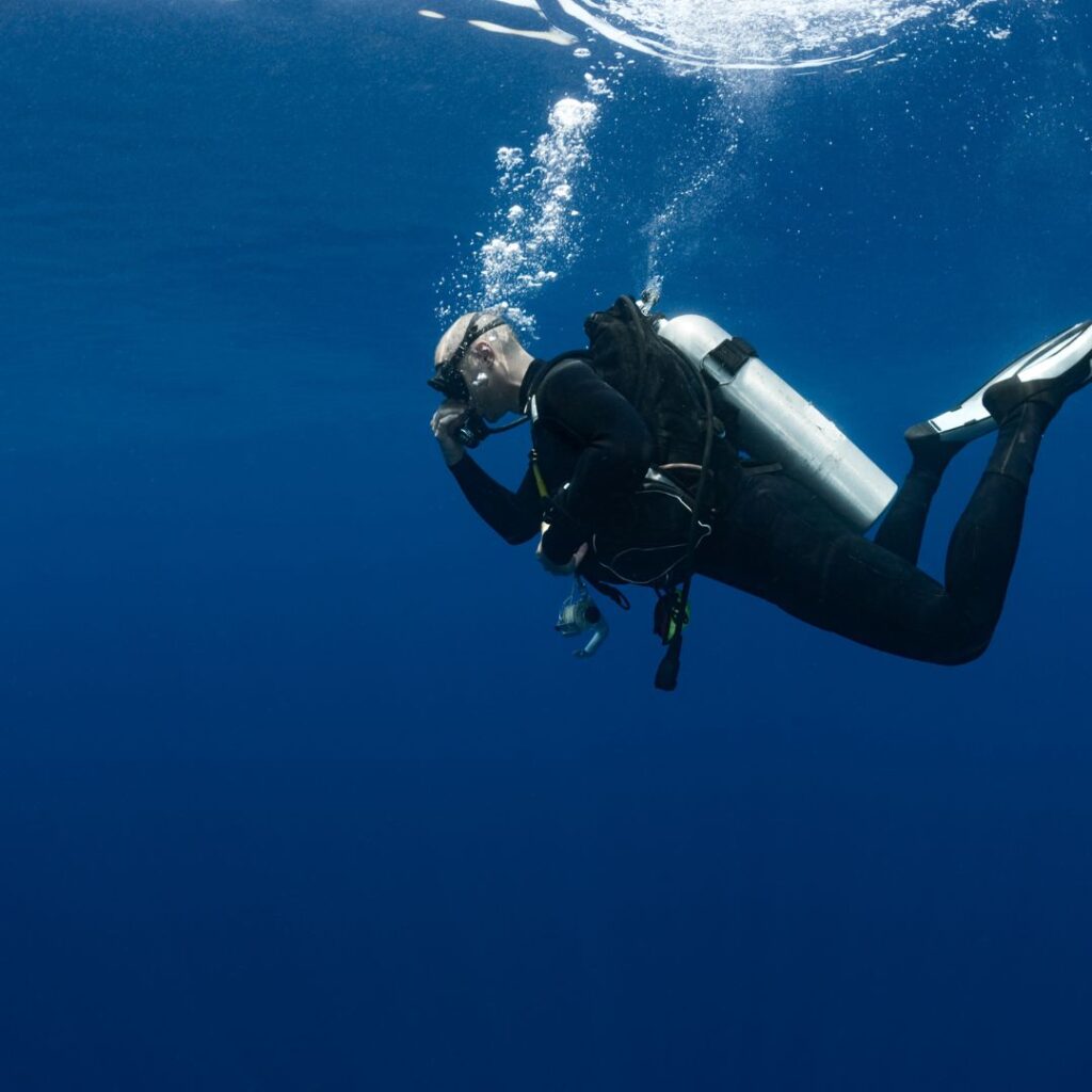 a person in a scuba suit and goggles underwater