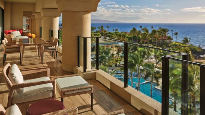 a balcony with chairs and a pool overlooking the ocean