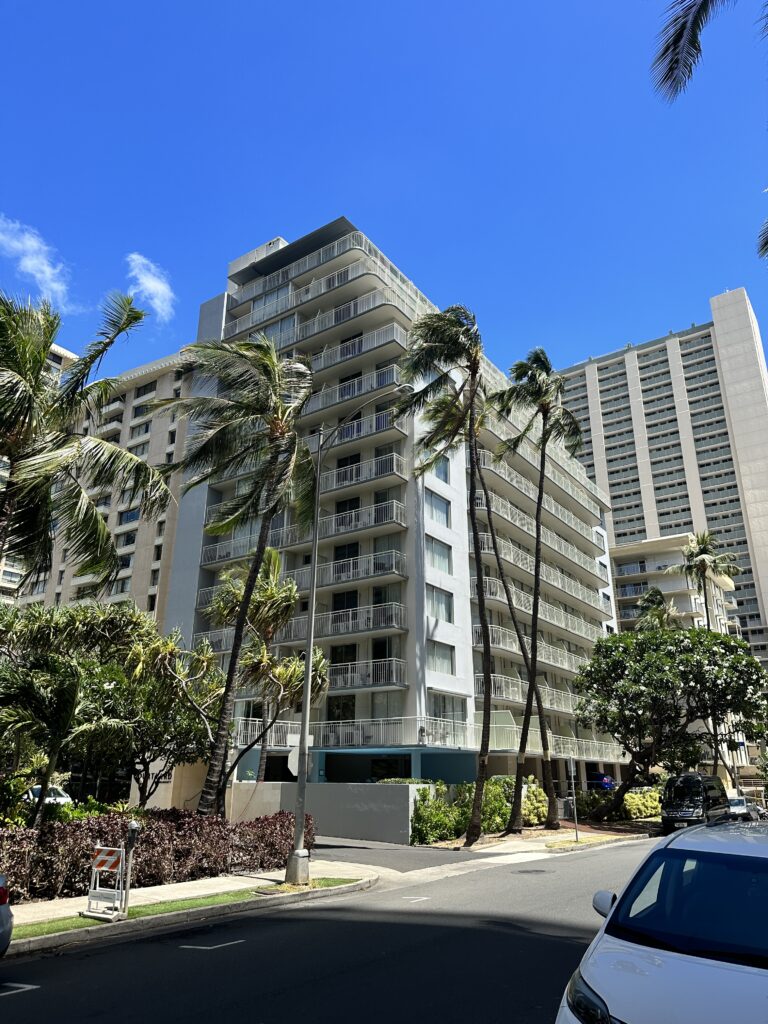 a tall building with palm trees