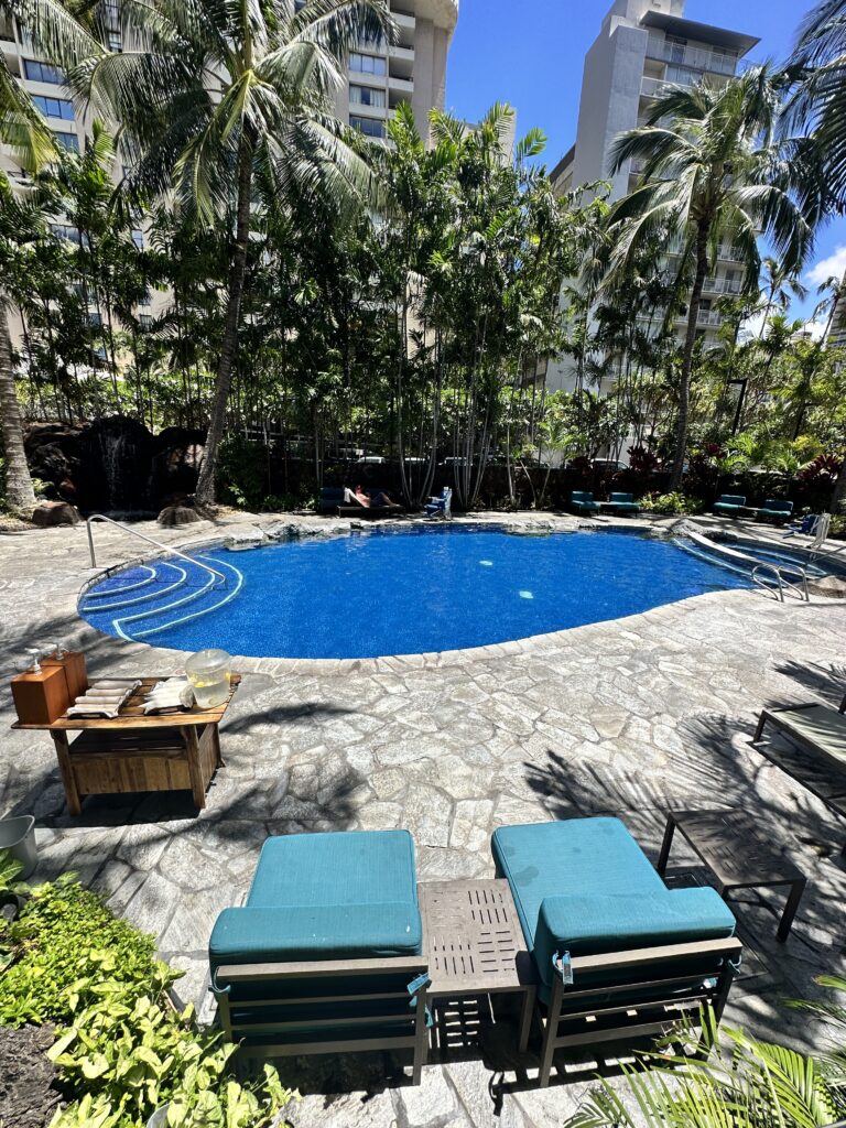 a pool with chairs and trees around it