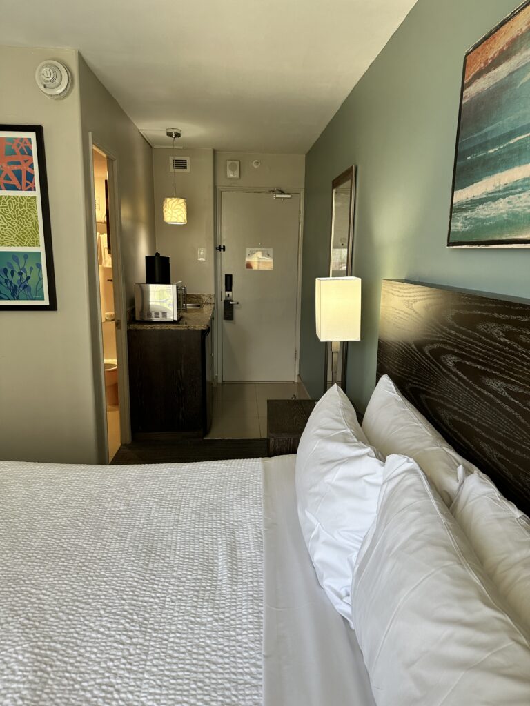 a bed with white pillows and a wood headboard in a hotel room