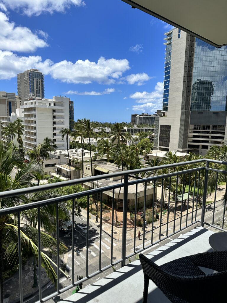 a balcony with a view of a city and palm trees