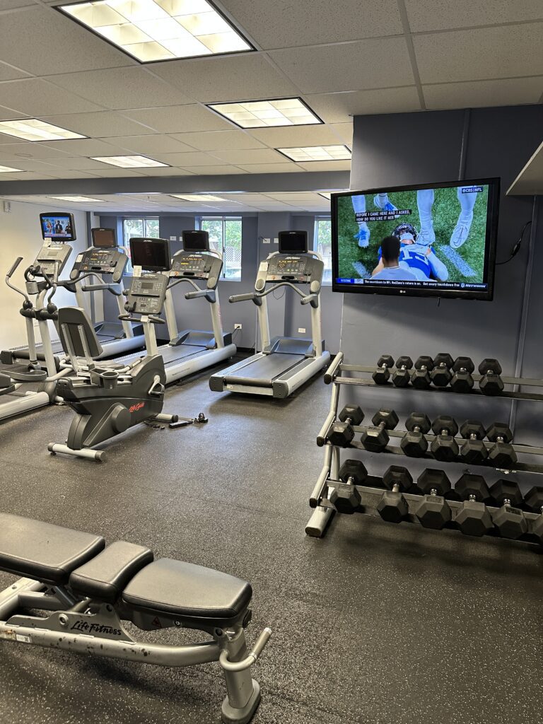 a room with exercise equipment and a television