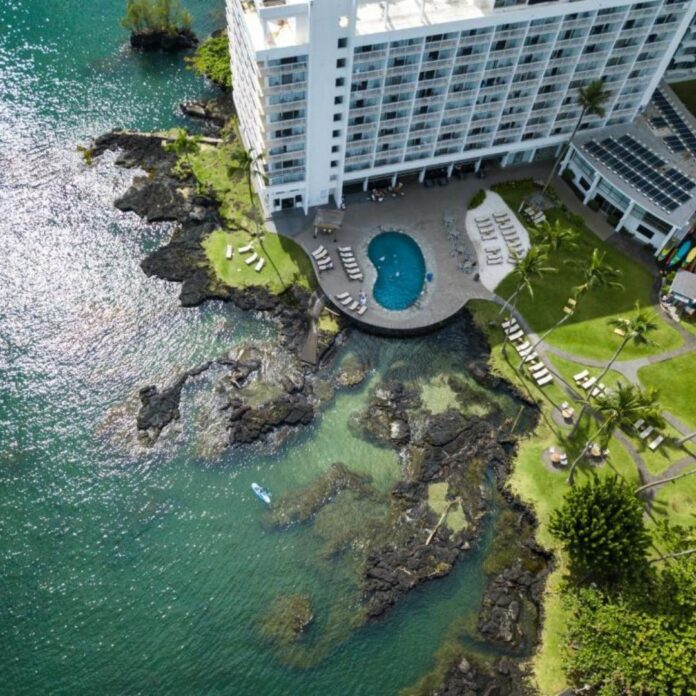 a hotel with a pool and a body of water