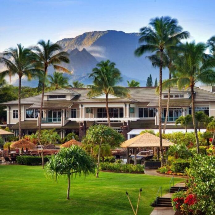 a large building with palm trees and a lawn