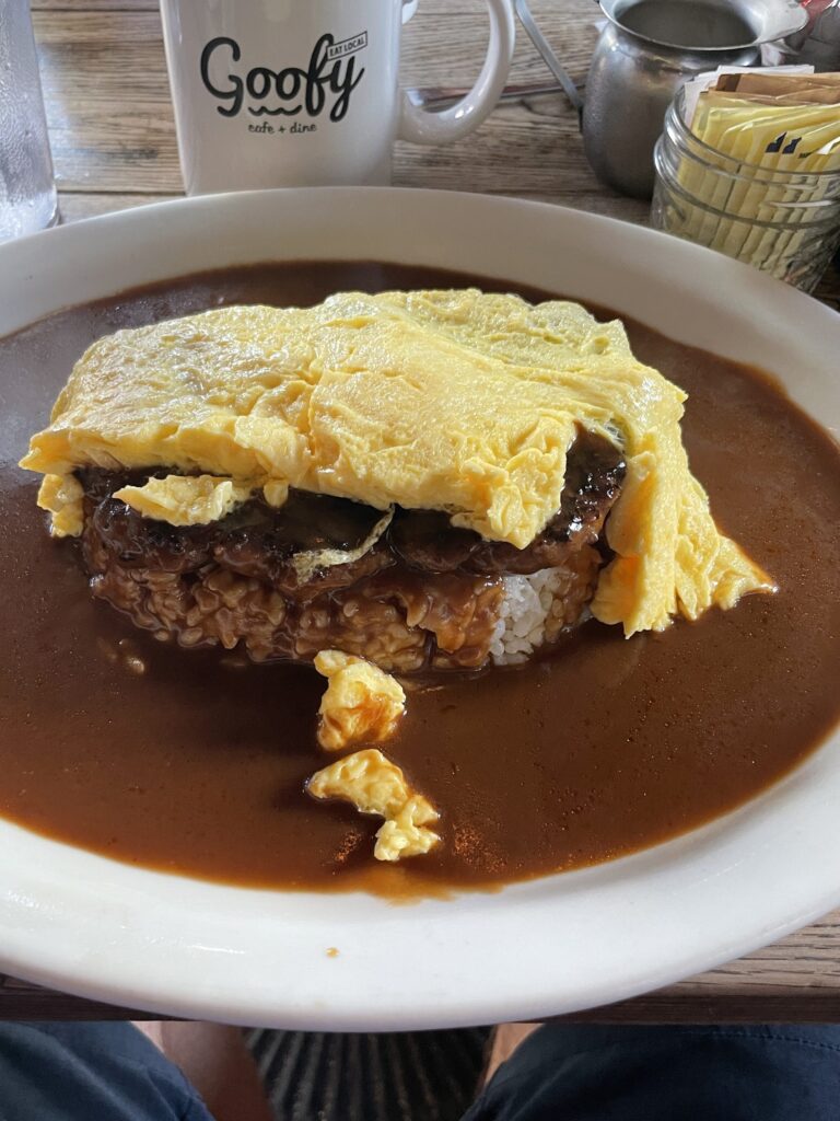 a plate of food with brown sauce and omelette