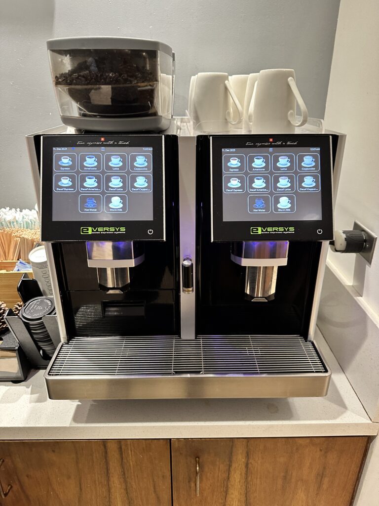 a machine with a screen and a container with coffee beans