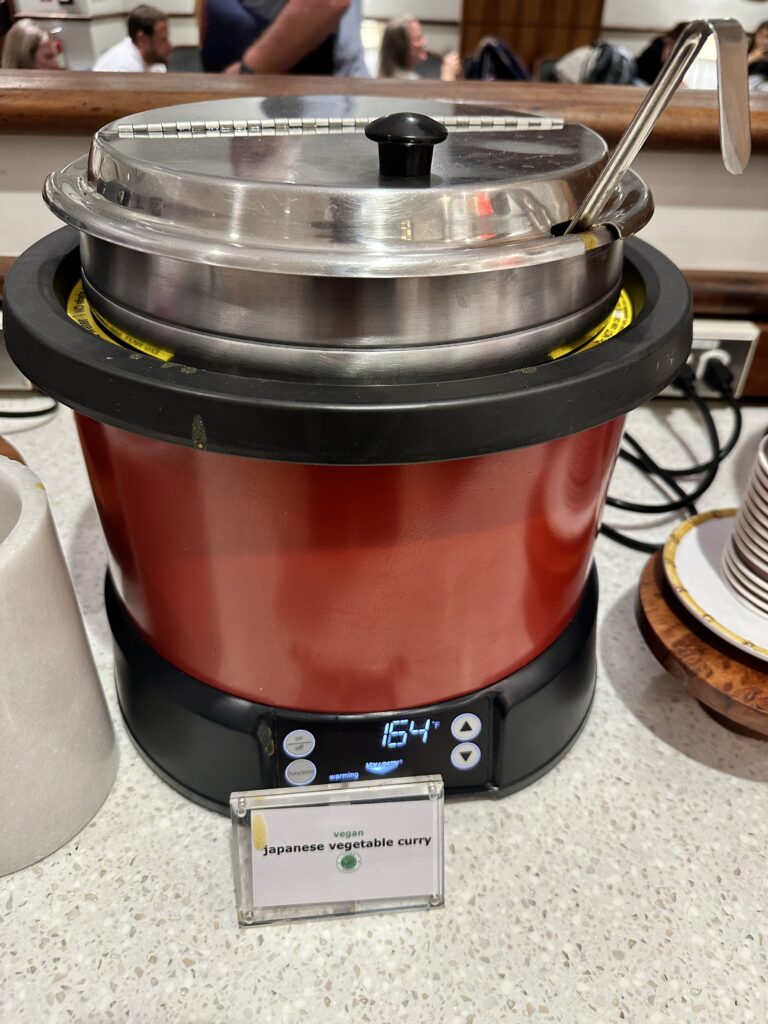 a red and black pot with a lid and spoons