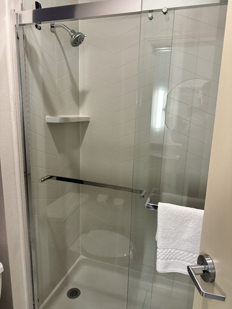 a shower with a white towel on a towel rack