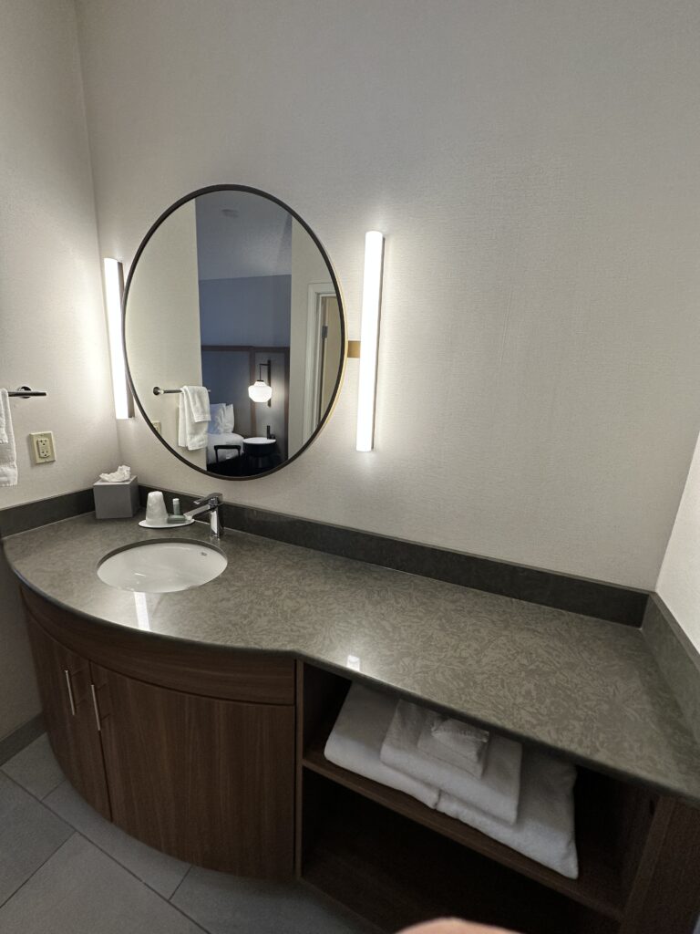 a bathroom with a round mirror