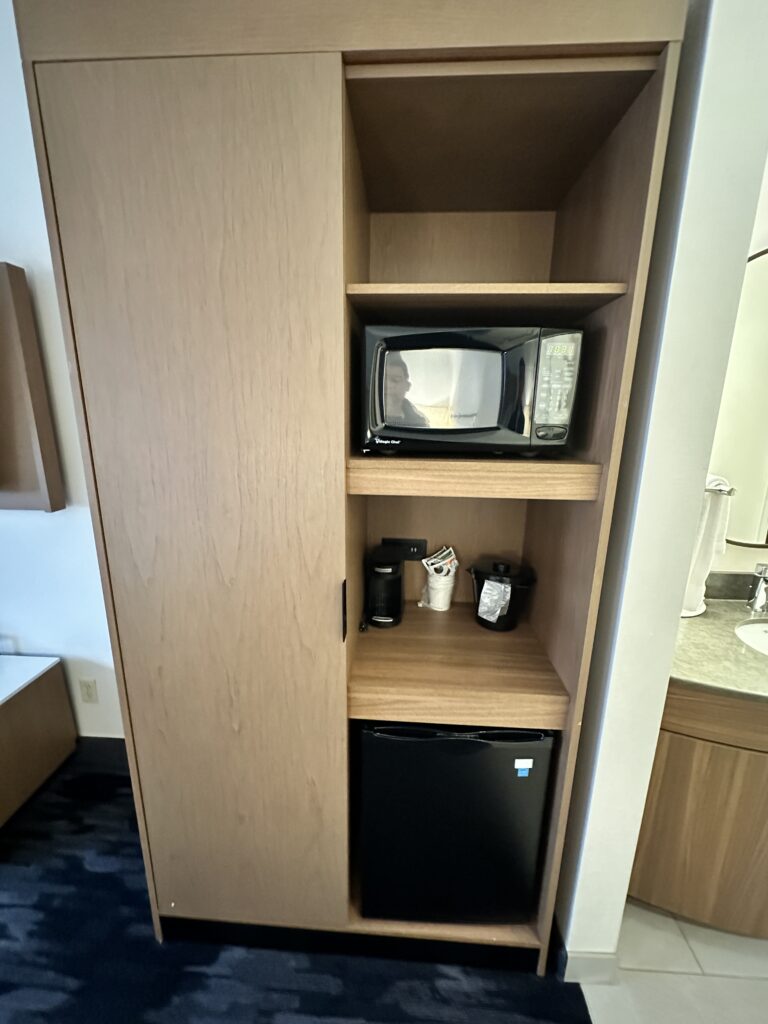 a microwave and small refrigerator in a cabinet