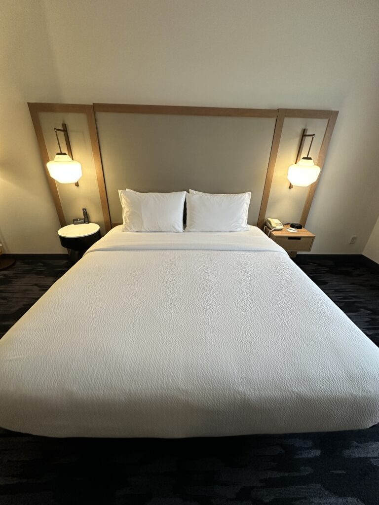 a bed with white sheets and pillows