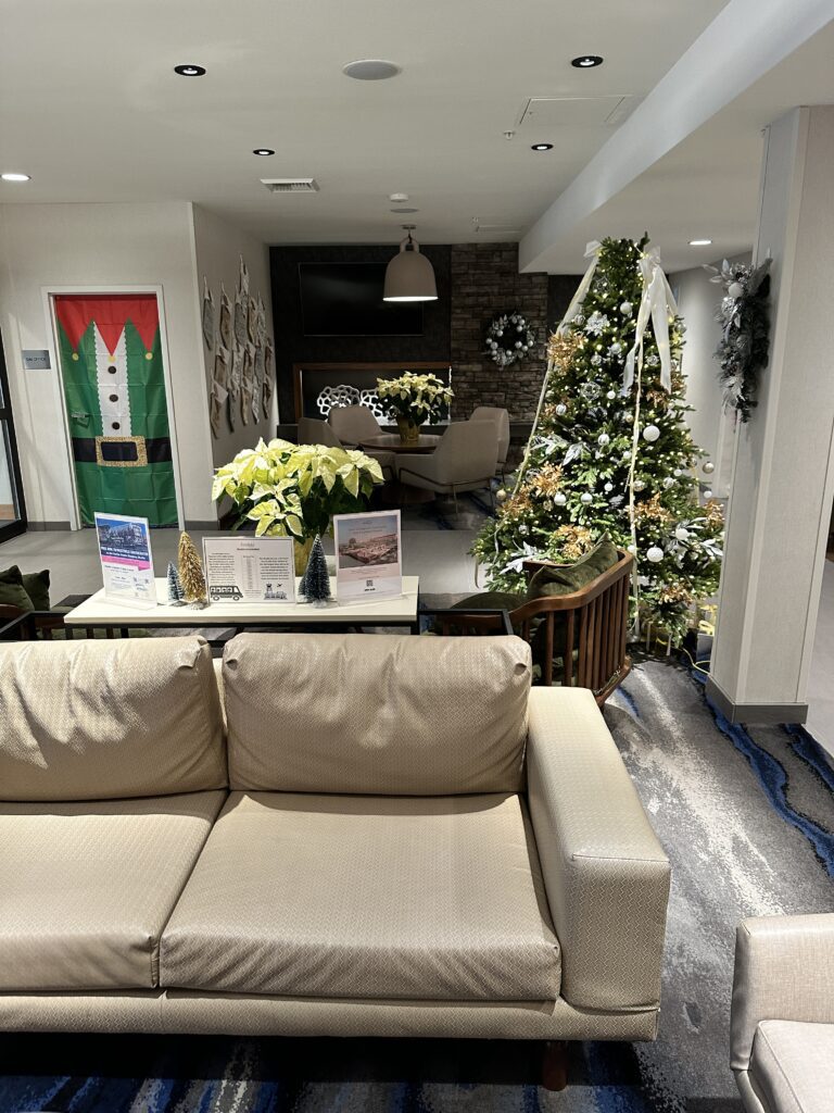 a couch and christmas tree in a room