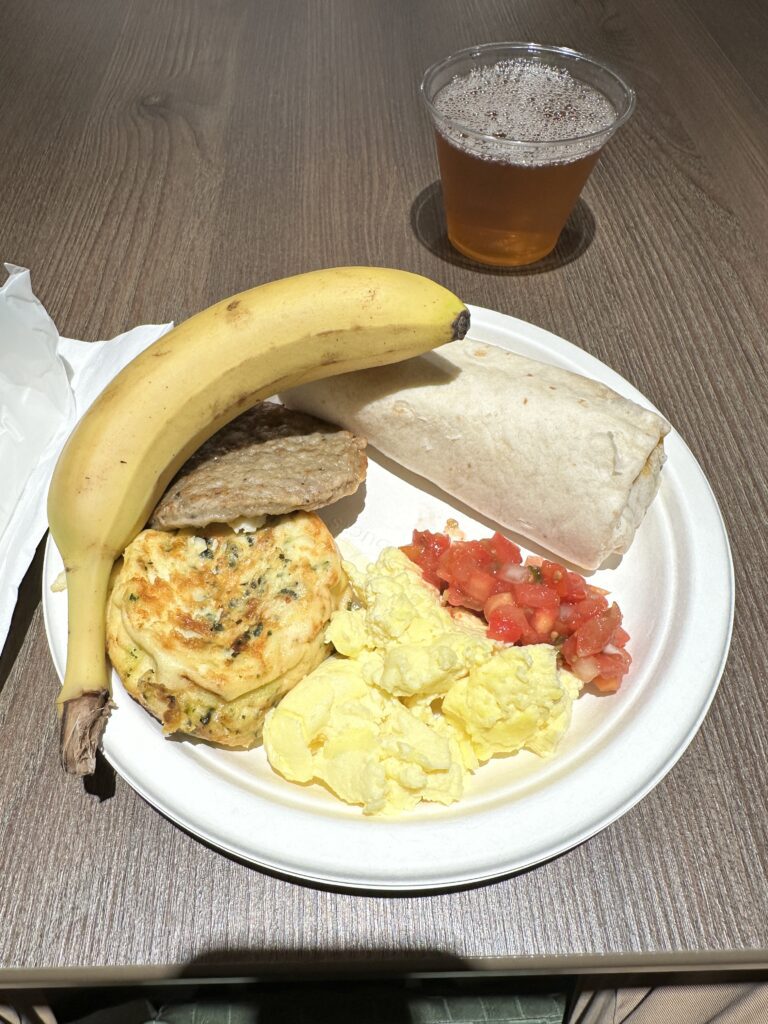 a plate of food with a banana and a glass of beer
