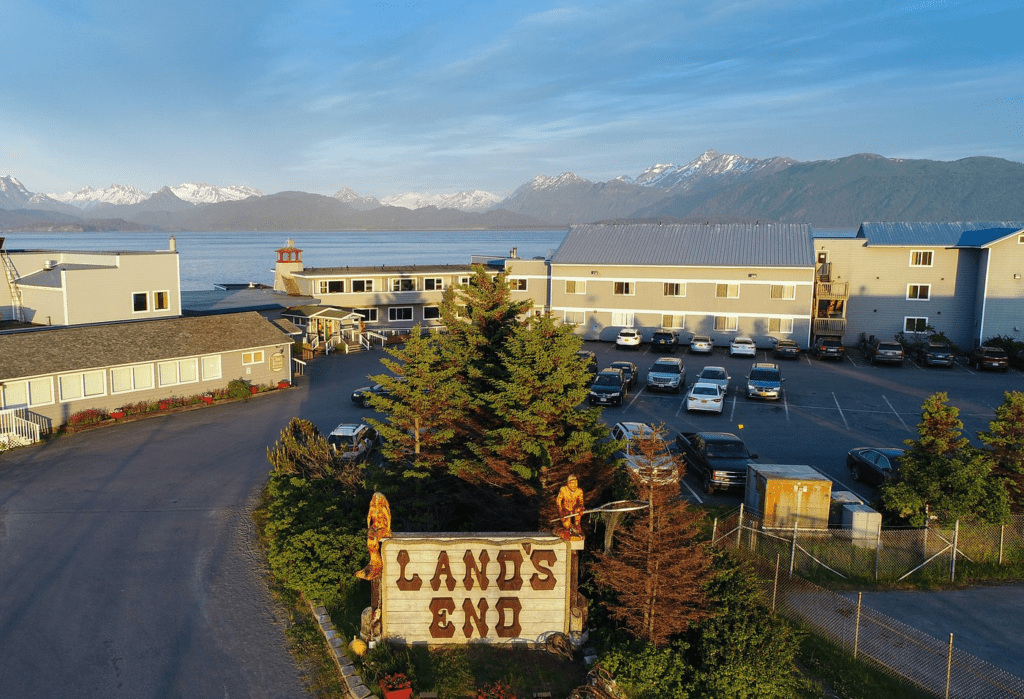 a parking lot with a sign and trees and a large body of water