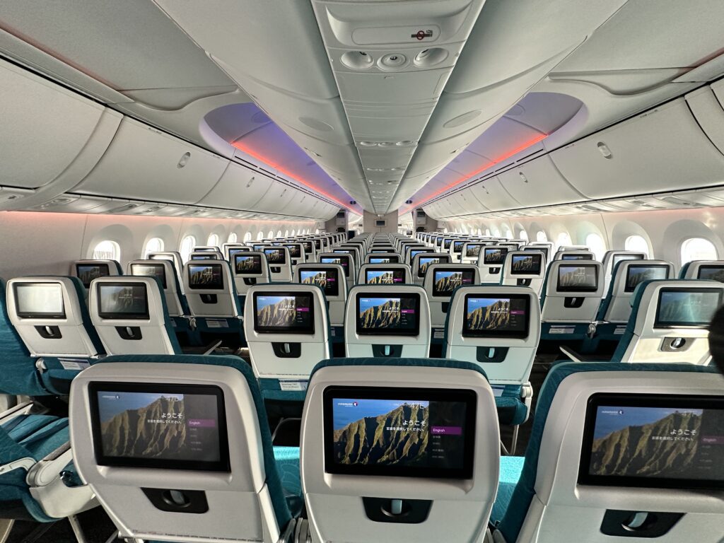 an airplane with rows of seats and monitors