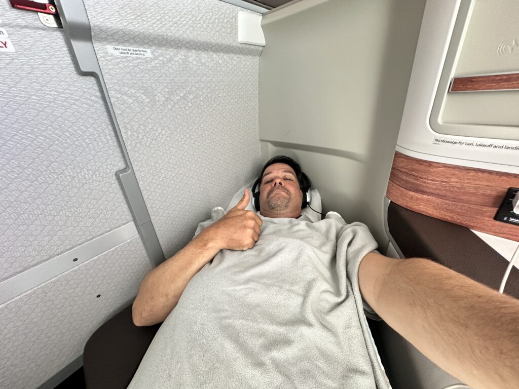 a man lying down in a chair with headphones and a thumbs up