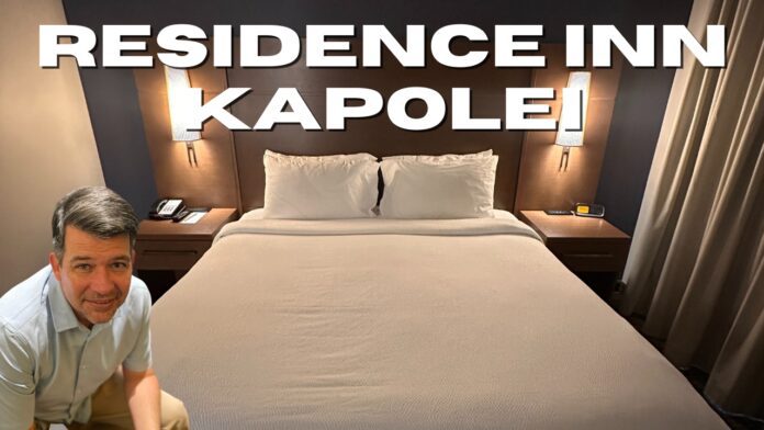 a bed with white sheets and a lamp on the side